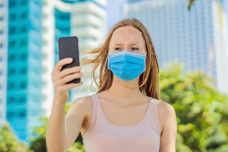 Girl holding smart phone covid-19 mask