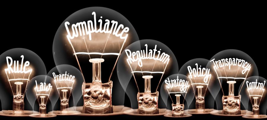 Photo of light bulbs with shining fibers in a shape of COMPLIANCE concept related words isolated on black background