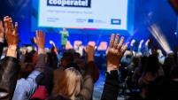 picture of an interreg event with attendees raising hands